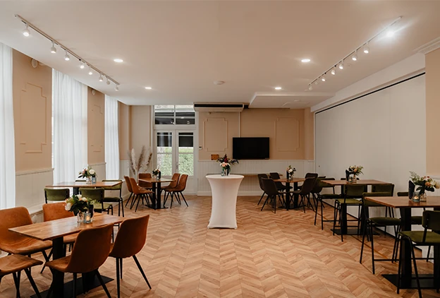 Zaalverhuur in Den Haag met lichte inrichting, tafels en stoelen voor bijeenkomsten