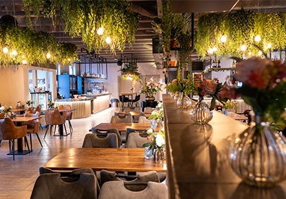 Sfeervolle zaal in Den Haag geschikt voor verhuur met planten en restaurant opstelling