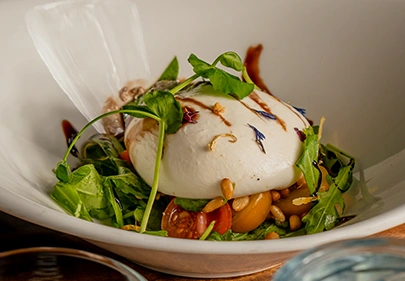 Verse burrata salade met rucola en tomaat bij restaurant in Den Haag