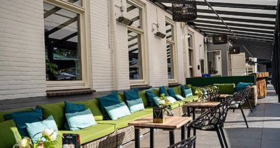 Gezellig terras met loungehoek en kussens onder overkapping in Den Haag