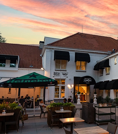 Voorgevel van restaurant met gezellig terras en parasols in Den Haag